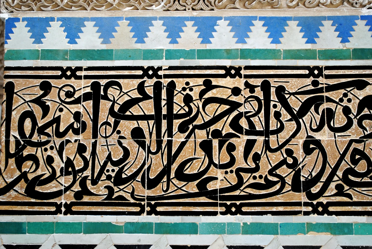 Photographed blue stepped Charafa frieze and calligraphic ceramic band at Al-Attarine Madrasa in Fès