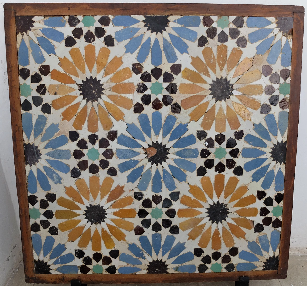 Photograph of a preserved fragment of geometric zellige from Badi Palace in Marrakesh